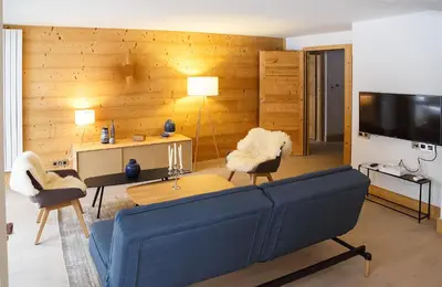 a living room with a blue couch and a tv at Luxury appart – Megève – АЕ202 in Megève