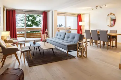 a living room with a couch and a dining room at Megève appart – 2 bedroms – AW301 in Megève