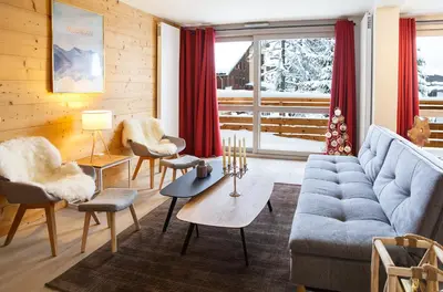 a living room with a blue couch and chairs at Megève appart – 2 bedroms – AW301 in Megève