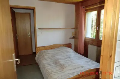 a bedroom with a bed in a room with a window at Les passereaux in Saint-Nicolas-de-Véroce