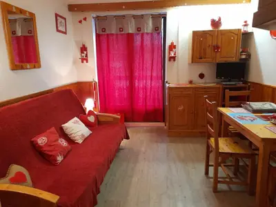 a living room with a red couch and a table at Samoëns studio in Samoëns