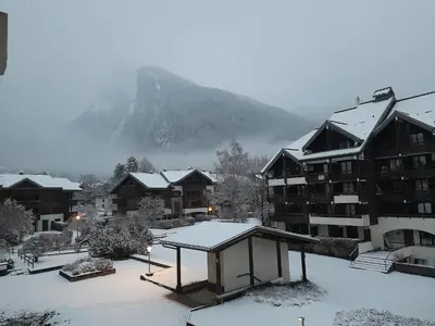 a resort with snow covered buildings and a mountain at Samoëns studio in Samoëns