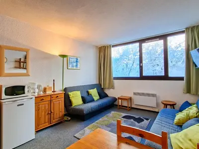 a living room with a blue couch and a kitchen at Studio spacieux pour 4 personnes, proche des pistes - FR-1-425-74 in Flaine