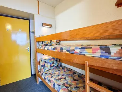 a room with two bunk beds and a yellow door at Studio spacieux pour 4 personnes, proche des pistes - FR-1-425-74 in Flaine