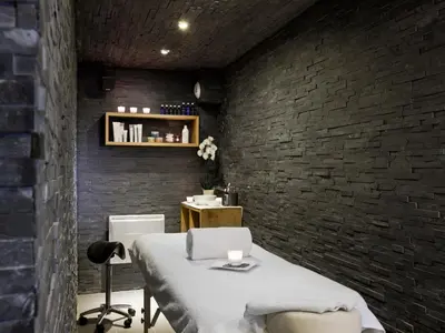 a room with a bed and a brick wall at Le Faucigny - Hotel de Charme & SPA in Chamonix-Mont-Blanc