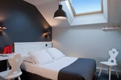 a bedroom with a bed and a desk and a window at Le Faucigny - Hotel de Charme & SPA in Chamonix-Mont-Blanc