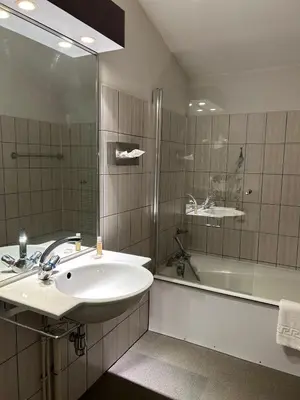 a bathroom with a sink and a shower and a tub at Hôtel Arbois Bettex in Saint-Gervais-les-Bains