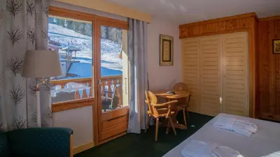 a bedroom with a bed and a table in a room at Hôtel Arbois Bettex in Saint-Gervais-les-Bains