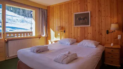 a large wooden building with snow on the roof at Hôtel Arbois Bettex in Saint-Gervais-les-Bains