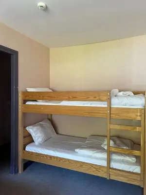 two bunk beds in a dorm room with white sheets at Hôtel Arbois Bettex in Saint-Gervais-les-Bains