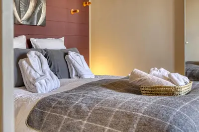 a bed with white towels and a basket on it at La Féline Blanche Adult Only in Saint-Gervais-les-Bains
