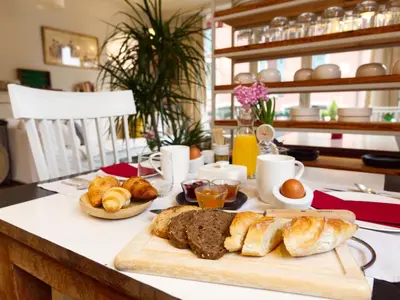 a table with bread and pastries on a table at La Féline Blanche Adult Only in Saint-Gervais-les-Bains