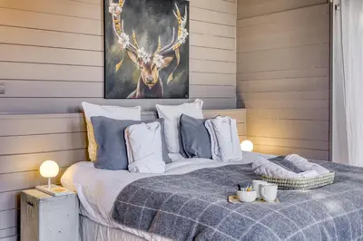 a bedroom with a bed with a picture of a deer at La Féline Blanche Adult Only in Saint-Gervais-les-Bains
