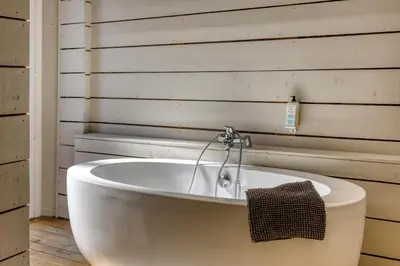 a white bath tub in a room with a wall at La Féline Blanche Adult Only in Saint-Gervais-les-Bains