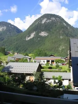 a view of a mountain with a house and a building at Le Bivouac in Sixt