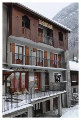 a building with balconies and a snow covered mountain at Le Bivouac in Sixt