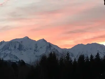a sunset over a snow covered mountain range at Sallanches 3101 Route de Nant Cruy immeuble le Grand R in Sallanches