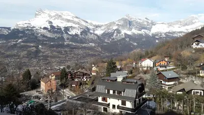 a town with snow capped mountains in the background at Appartement Saint Gervais les Bains in Saint-Gervais-les-Bains
