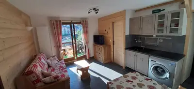 a living room with a couch and a kitchen at Appartement Saint Gervais les Bains in Saint-Gervais-les-Bains