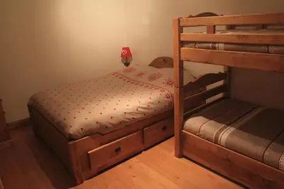 a bedroom with a bed and a wooden door at At Home in Les Carroz d'Araches