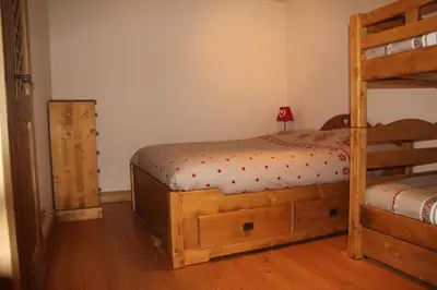 a bedroom with two bunk beds and a ladder at At Home in Les Carroz d'Araches