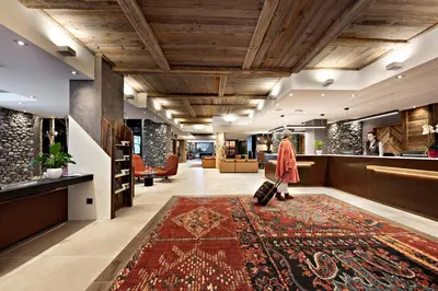 a lobby with a rug on the floor at MGM Hôtels & Résidences - Hôtel Les Suites d'Alexane in Samoëns