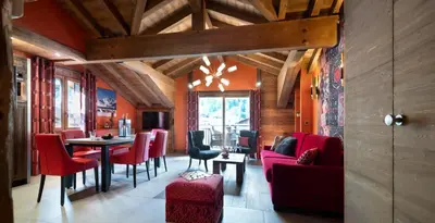 a dining room with red chairs and a table at MGM Hôtels & Résidences - Hôtel Les Suites d'Alexane in Samoëns