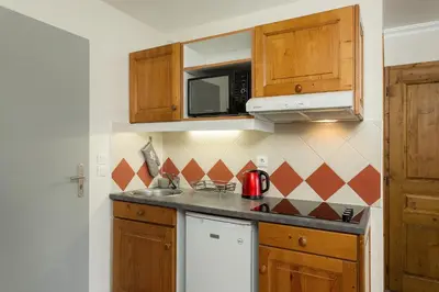 a kitchen with a sink and a microwave at Apartment Aiglons - Central Chamonix Mountain Haven in Chamonix-Mont-Blanc