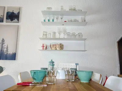 a dining room table with bowls and glasses on shelves at Studio Le Sapin by Interhome in Demi-Quartier
