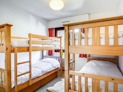a white bed in a bedroom with pictures on the wall at Apartment Fleurs des Alpes-1 by Interhome in Saint-Gervais-les-Bains
