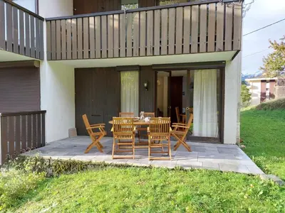 a bedroom with two bunk beds and a chair at Apartment Le Sporting-1 by Interhome in Saint-Gervais-les-Bains