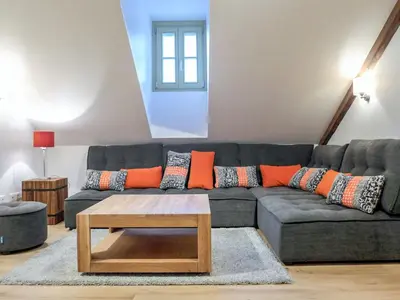 a living room with a gray couch with orange pillows at Apartment Le Chalet Suisse-3 by Interhome in Chamonix-Mont-Blanc