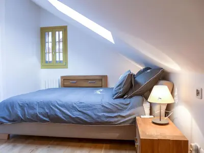 a bedroom with a bed with blue sheets and a window at Apartment Le Chalet Suisse-3 by Interhome in Chamonix-Mont-Blanc