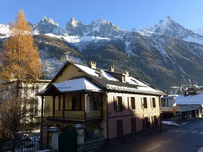 a house with snowy mountains in the background at Apartment Le Chalet Suisse-3 by Interhome in Chamonix-Mont-Blanc