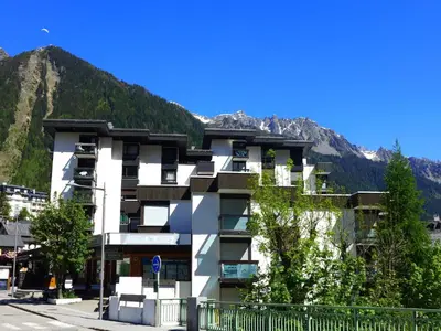 a white building with a mountain in the background at Studio L'Aiguille du Midi-7 by Interhome in Chamonix-Mont-Blanc