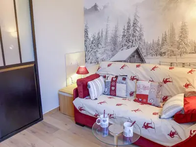 a room with a table and a tv and shelves at Studio Le Bois du Bouchet-6 by Interhome in Chamonix-Mont-Blanc
