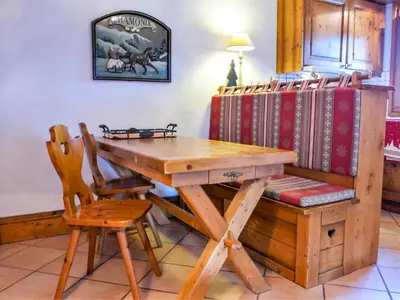 a wooden table with a bench and a bunch of books at Apartment Ginabelle 1-1 by Interhome in Chamonix-Mont-Blanc