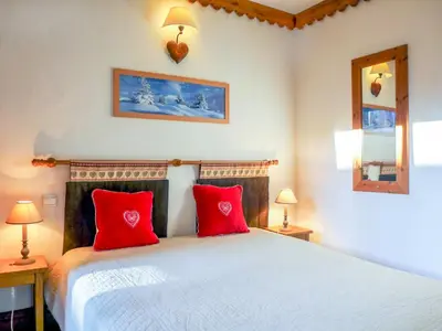 a bedroom with a large bed with red pillows at Apartment Ginabelle 1-1 by Interhome in Chamonix-Mont-Blanc