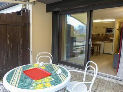 a table and chairs on a patio with a glass door at Studio Le Pramouny-2 by Interhome in Chamonix-Mont-Blanc