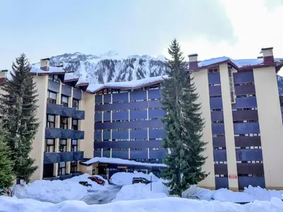 a hotel in the snow with a mountain in the background at Apartment Grand Roc-4 by Interhome in Chamonix-Mont-Blanc