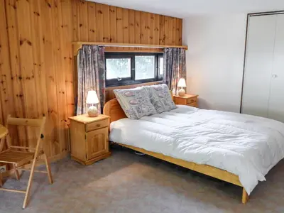 a bedroom with a bed and a wooden wall at Apartment Grand Roc-4 by Interhome in Chamonix-Mont-Blanc