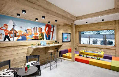 a room with wooden walls and a bar with colorful furniture at MGM Hôtels & Résidences - Résidence Chalets Elena in Les Houches