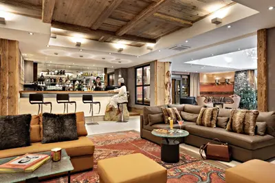 a living room with couches and a bar at MGM Hôtels & Résidences - Résidence Alexane in Samoëns