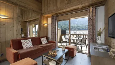 a living room with a couch and a table at MGM Hôtels & Résidences - Résidence Alexane in Samoëns