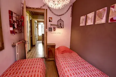 two beds in a room with pink walls and a chandelier at DIFY Cosy - Chamonix in Chamonix-Mont-Blanc