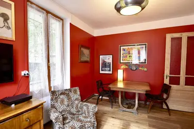 a living room with red walls and a table and chairs at DIFY Cosy - Chamonix in Chamonix-Mont-Blanc