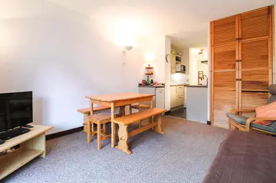 a living room with a table and a kitchen at Spacious Apartment Iris, Flaine Foret in Flaine