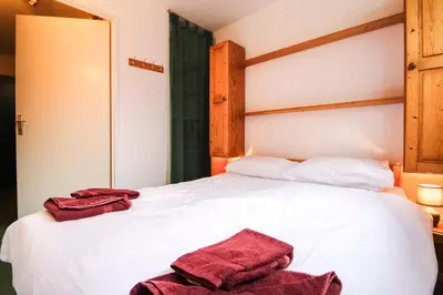 a bedroom with a white bed with two towels on it at Spacious Apartment Iris, Flaine Foret in Flaine