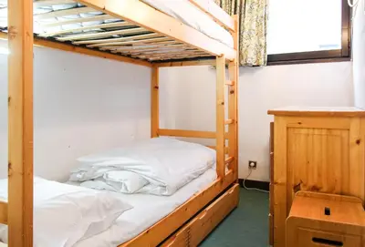 a bunk bed room with two bunk beds and a table at Spacious Apartment Iris, Flaine Foret in Flaine
