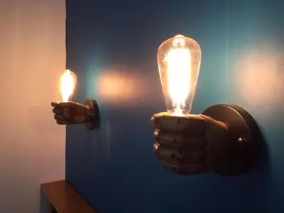 a person holding up a light bulb on a wall at Chamois Blanc in Chamonix-Mont-Blanc